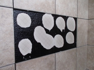 Hobbs observed that “such a small amount of thin-set patties were utilized, that tape and even screws (piercing the waterproof membrane) were used to hold the tiles up and prevent them from sliding."